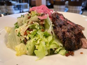 A salad with steak and pickled onions.